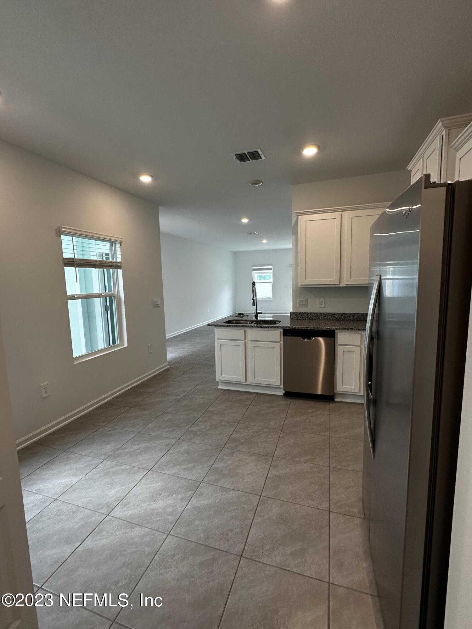 409 Talulla Trail St. Augustine, FL 32095 - Photo 31 of 58 a kitchen with stainless steel appliances granite countertop a refrigerator and a sink