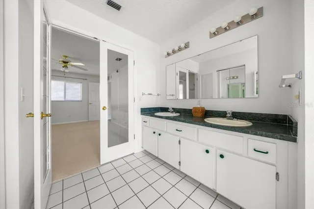 a spacious bathroom with a granite countertop sink and a mirror