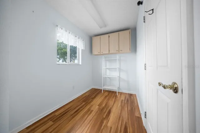 a view of a room with wooden floor and a window