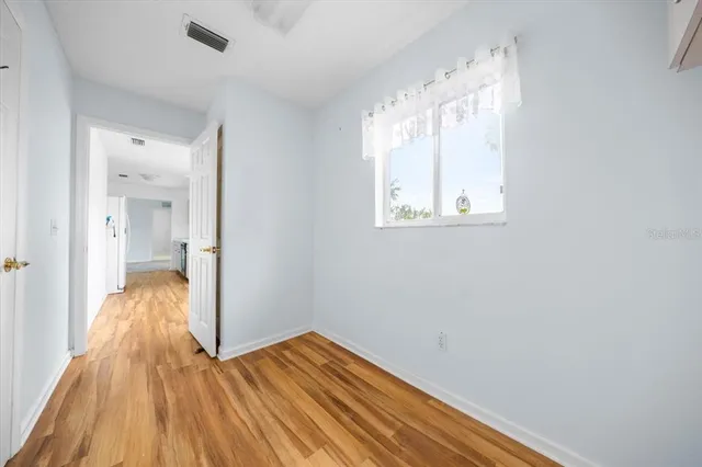 a view of a room with wooden floor and a bathroom