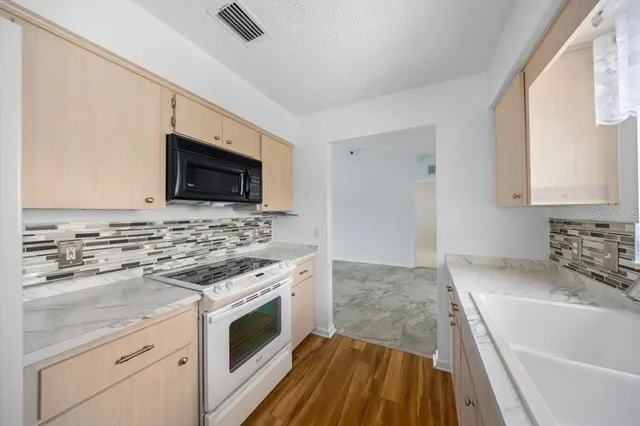 a kitchen with a sink stove and microwave