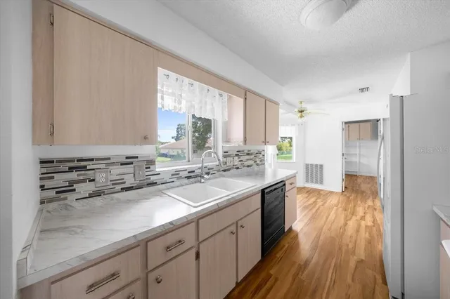 a kitchen with sink stove and refrigerator