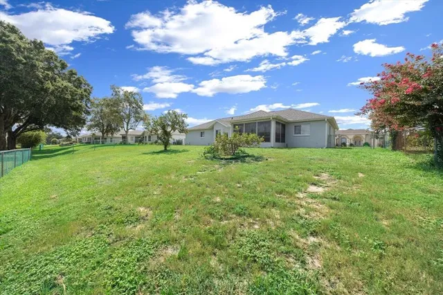 a view of a house with a big yard and large trees