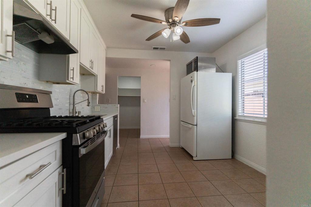15523 Studebaker Road Norwalk, CA 90650 - Photo 56 of 59 a kitchen with stainless steel appliances granite countertop a stove a refrigerator and a sink