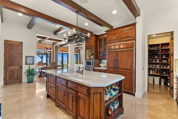 a utility room with stainless steel appliances granite countertop a sink and a refrigerator