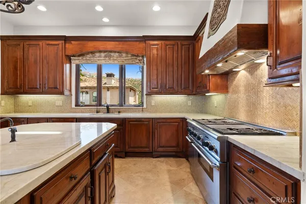 a kitchen with granite countertop a sink and a stove