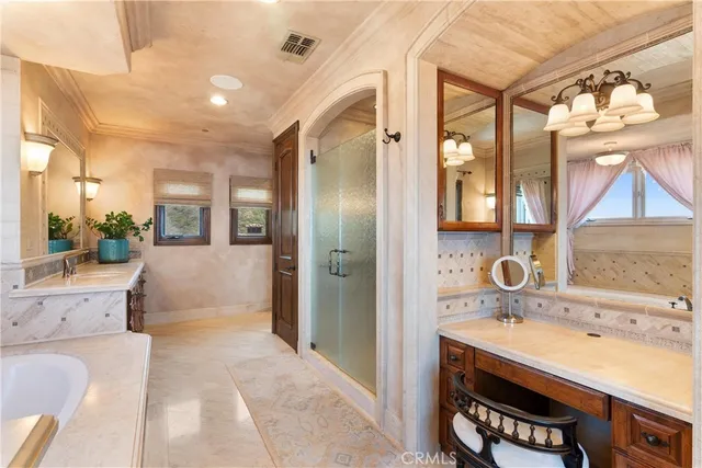 a spacious bedroom with a bed and a chandelier