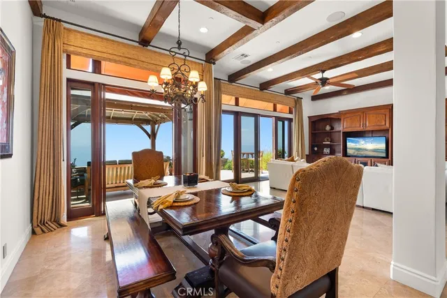 a dining room with furniture a chandelier and wooden floor