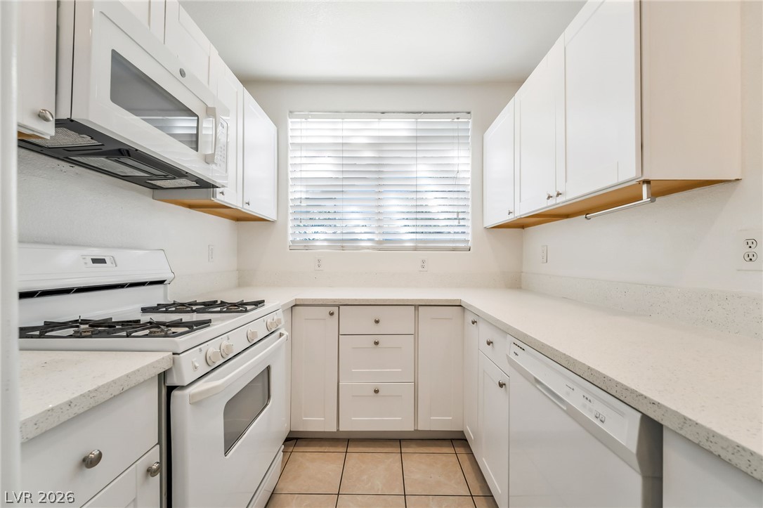 2201 Ramsgate Drive, Unit 811 Henderson, NV 89074 - Photo 15 of 36 White cabinetry and countertops provide a crisp, clean aesthetic in this well-appointed culinary space.