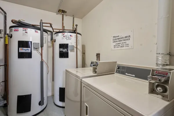 a utility room with dryer washer and a view of living room