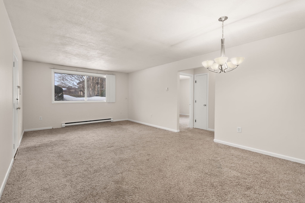 121 Bailey Street, Unit D31 Worcester, MA 01602 - Photo 6 of 25 an empty room with windows and chandelier