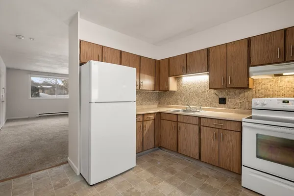 a kitchen with a refrigerator sink and cabinets