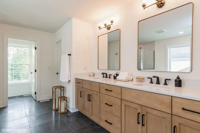 a bathroom with a double vanity sink a mirror and a bathtub
