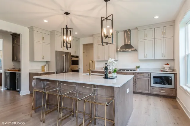 a kitchen with kitchen island a stove a table a sink and cabinets