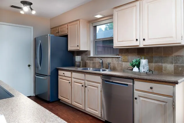a kitchen with stainless steel appliances granite countertop white cabinets and a stove