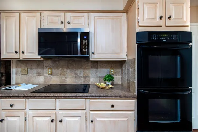 a kitchen with granite countertop a sink a window and cabinets