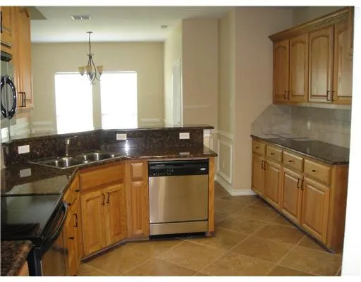 a kitchen with stainless steel appliances granite countertop a sink stove and cabinets
