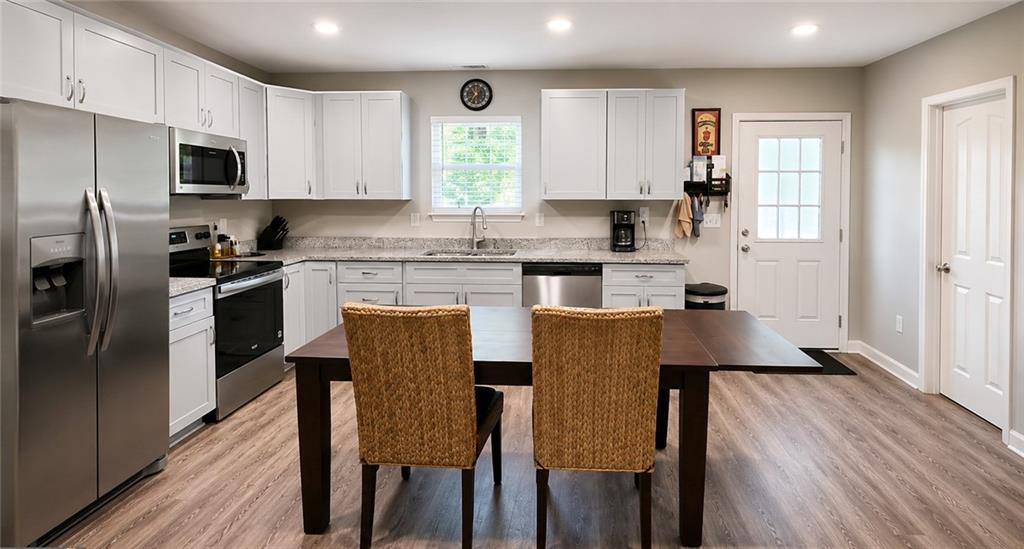 2956 Westmoreland Road Cleveland, GA 30528 - Photo 8 of 22 a kitchen with stainless steel appliances granite countertop a table chairs microwave and sink