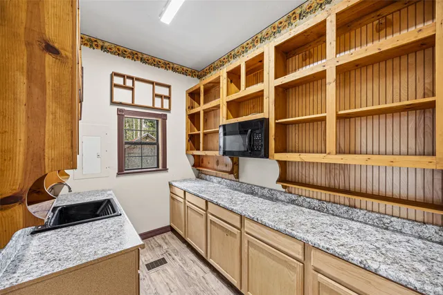 a kitchen with granite countertop wooden cabinets and a stainless steel appliances