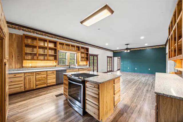 a kitchen with a stove and a wooden floor