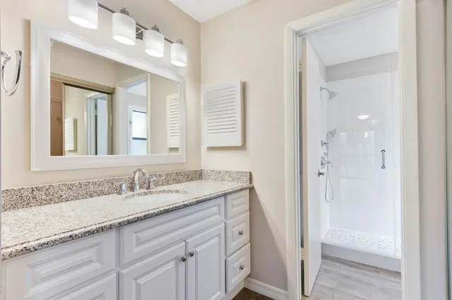 a bathroom with a granite countertop sink mirror and double
