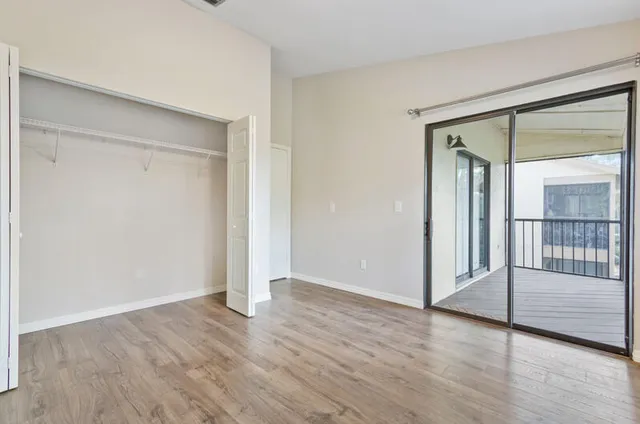 an empty room with wooden floor and door