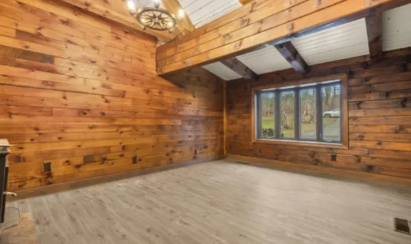 a view of an empty room with wooden floor and door