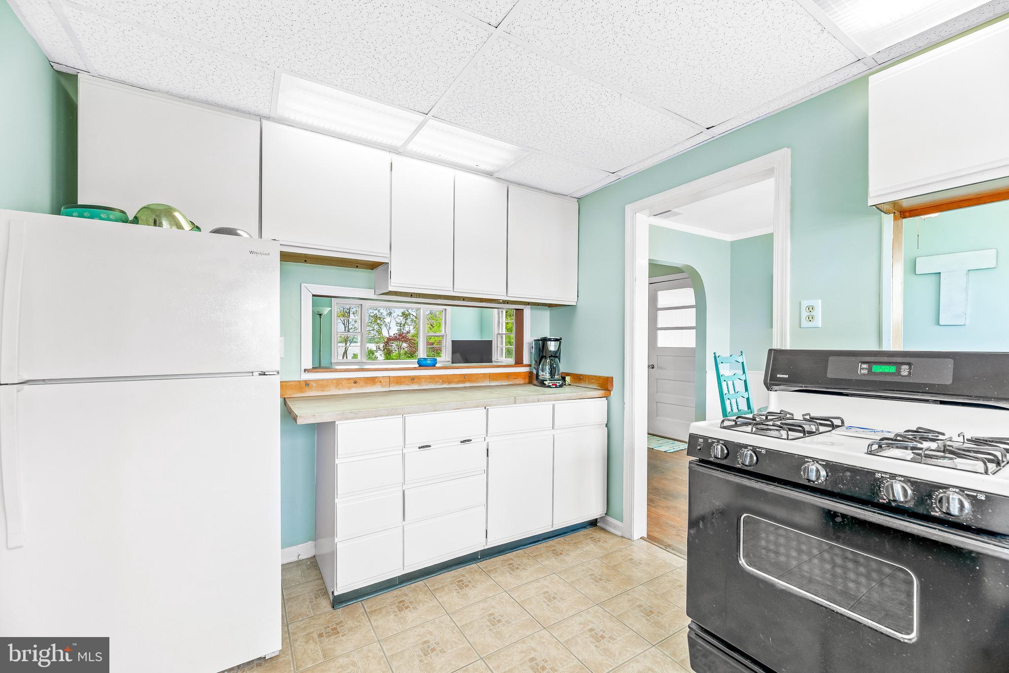 16410 Fishermen Way Ridge, MD 20680 - Photo 13 of 34 a kitchen with stainless steel appliances granite countertop a sink stove and refrigerator