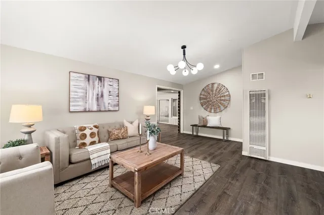 a living room with furniture a chandelier and a window