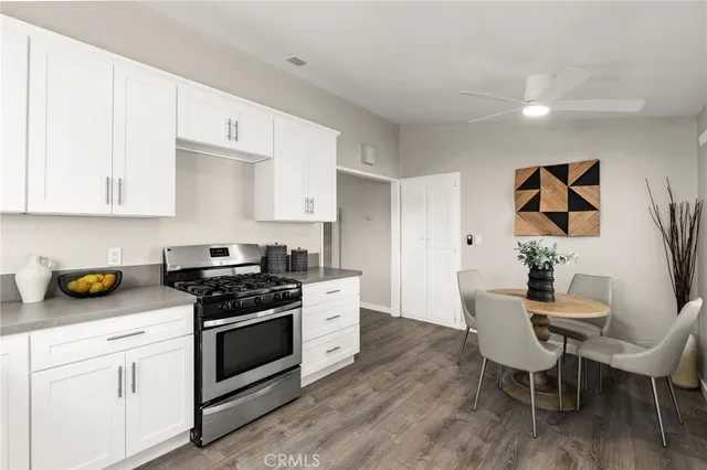 a kitchen with stainless steel appliances a stove a sink cabinets and wooden floor