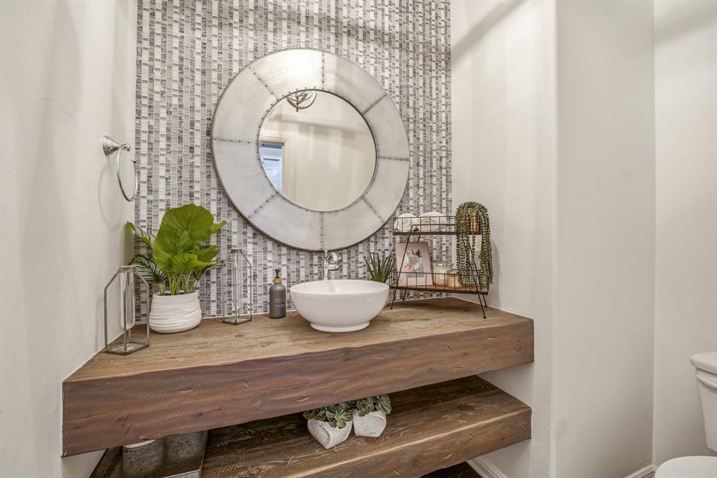 2009 Tree Top Court Granbury, TX 76049 - Photo 20 of 40 a bathroom with a sink a mirror and a potted plant