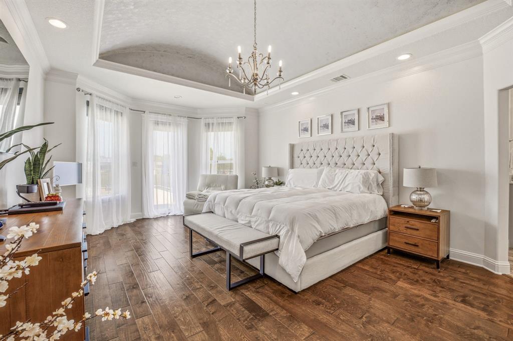 2009 Tree Top Court Granbury, TX 76049 - Photo 21 of 40 a spacious bedroom with a bed and a chandelier