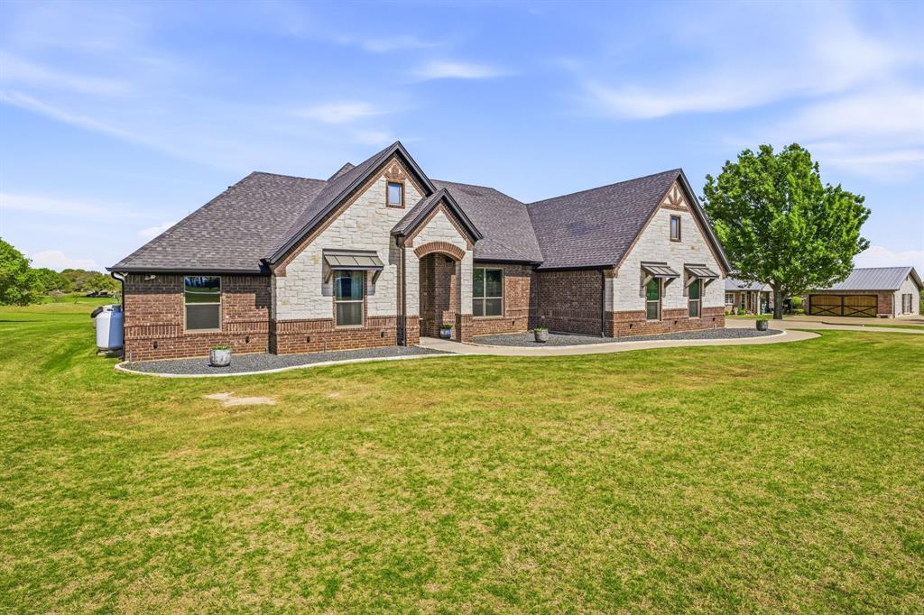 2009 Tree Top Court Granbury, TX 76049 - Photo 4 of 40 a front view of a house with garden