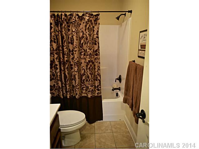 3334 Beaty Road Gastonia, NC 28056 - Photo 15 of 16 a bathroom with a toilet and a shower curtain
