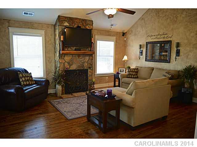 3334 Beaty Road Gastonia, NC 28056 - Photo 6 of 16 a living room with furniture a fireplace a flat screen tv and wooden floor