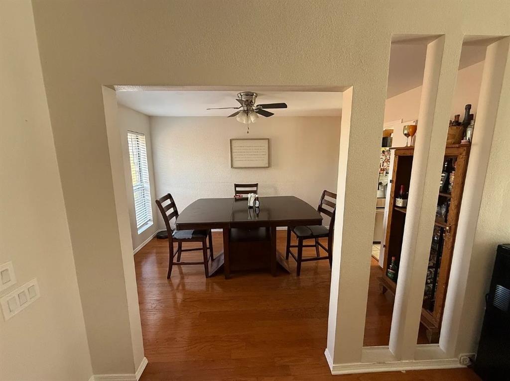 6505 Mc Cormick Ranch Court Plano, TX 75023 - Photo 4 of 21 Dining area featuring wood-finish flooring, a ceiling fan with integrated lighting, and natural light from a window with horizontal blinds