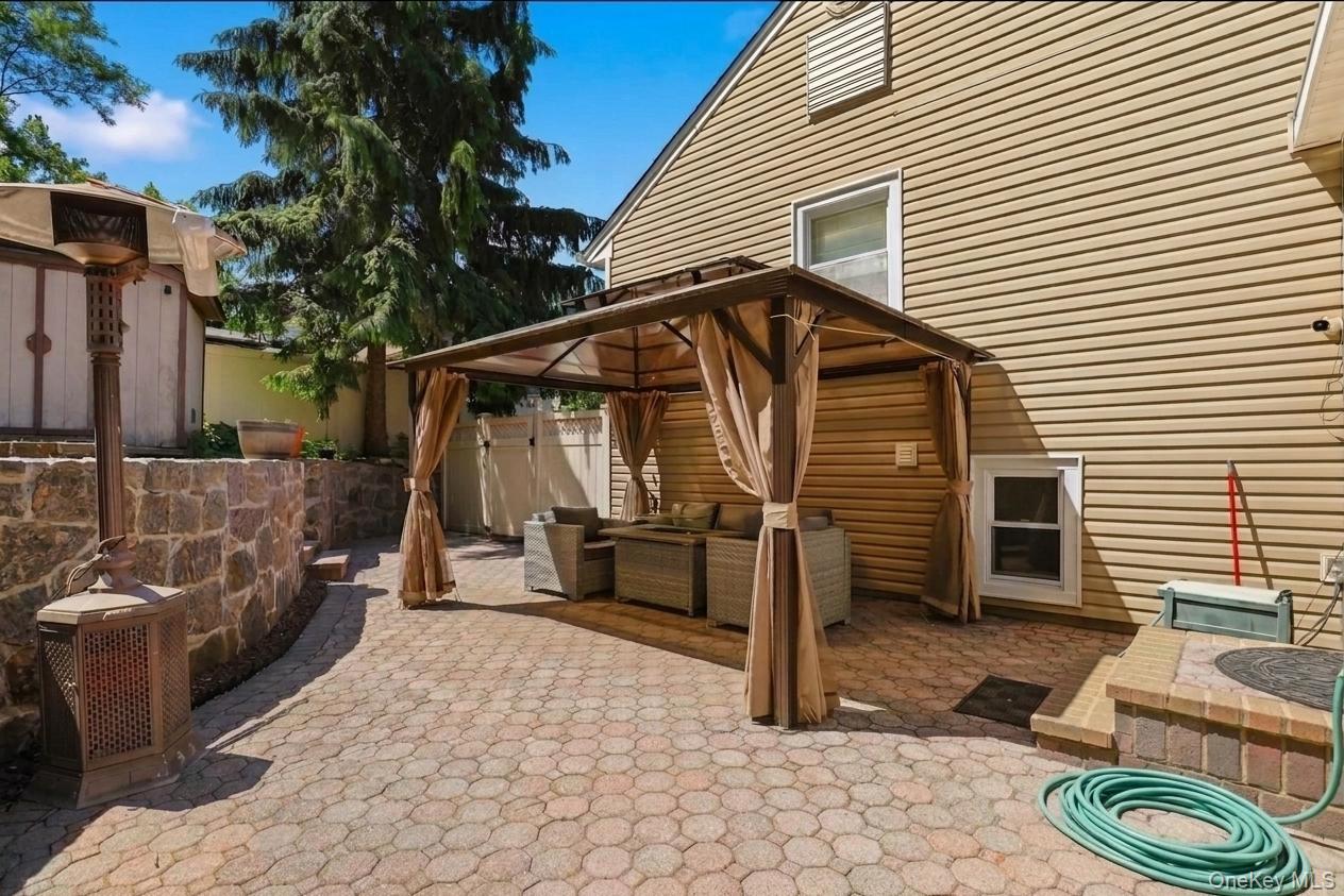 29 Montrose Road Yonkers, NY 10710 - Photo 29 of 39 Paved patio area featuring a covered gazebo structure, stone retaining walls, and a large mature tree