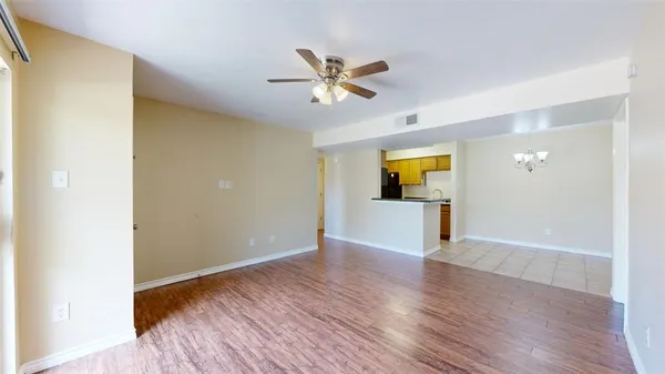 a view of a big room with wooden floor and windows