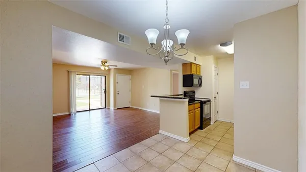 a view of a kitchen with a sink dishwasher and a refrigerator with wooden floor