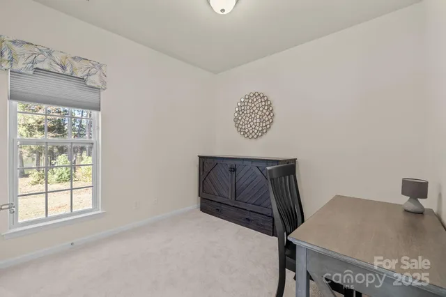 a view of a room that has a table and a chair in it