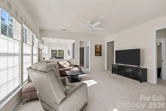 a view of a white house with a large window and yard