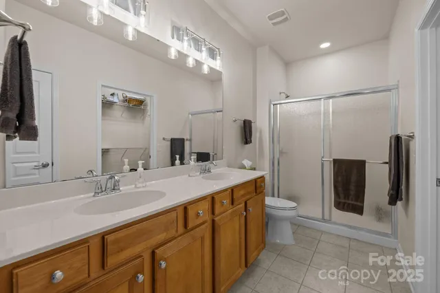 a bathroom with a sink a toilet a mirror and shower