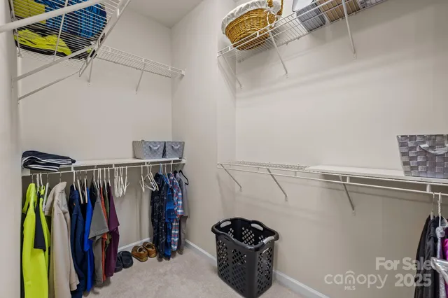 a view of walk in closet with clothes and shoes