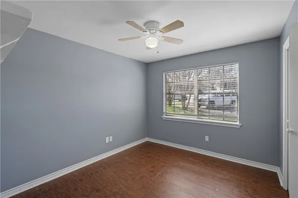 an empty room with a window and a ceiling fan