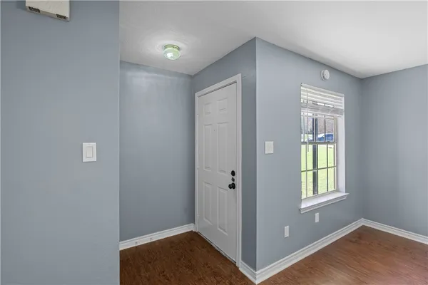 a view of an empty room with window and closet area