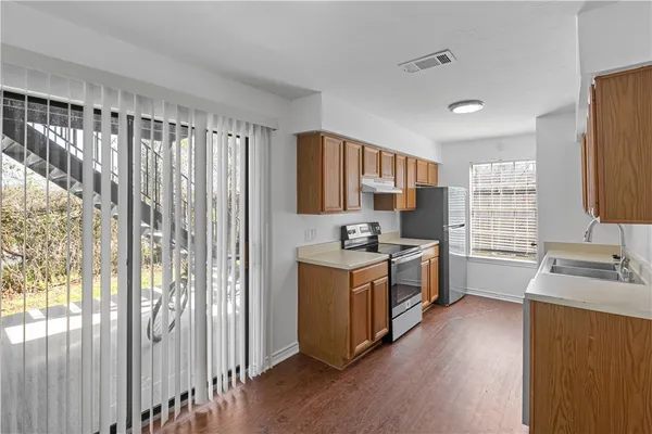 a kitchen with stainless steel appliances granite countertop a stove a sink and a refrigerator
