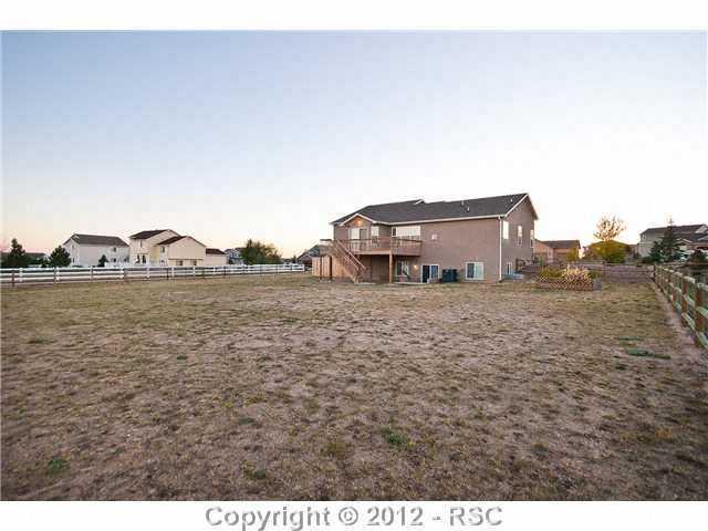 8739 Del Rio Road Peyton, CO 80831 - Photo 24 of 25 Another view of the ½ acre fenced lot that includes the back deck and covered patio.
