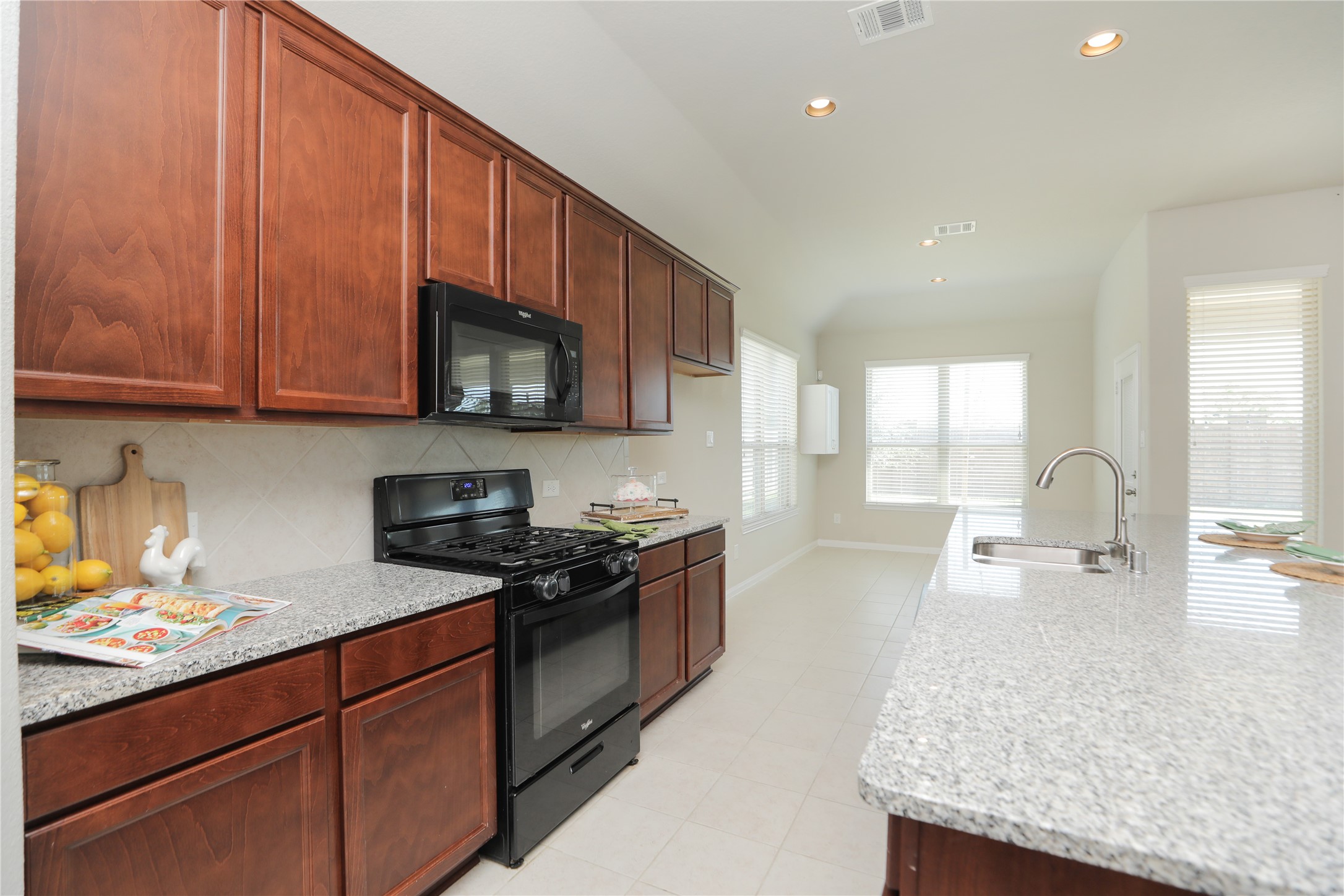 17506 Field Row Trail Hockley, TX 77447 - Photo 5 of 27 a kitchen with stainless steel appliances granite countertop wooden cabinets a stove top oven a sink and dishwasher
