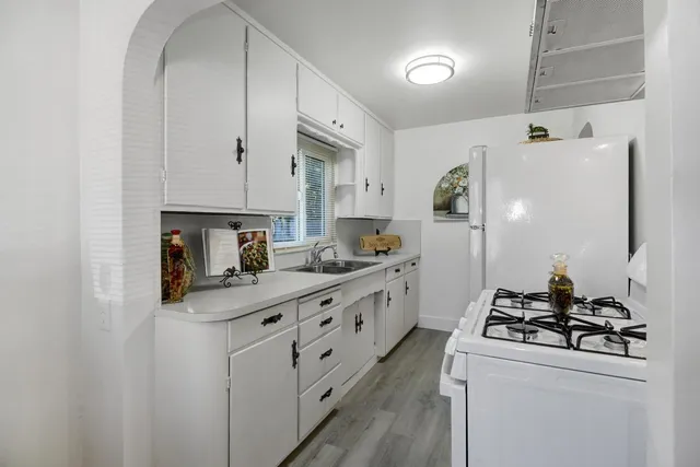 a kitchen with stainless steel appliances a sink stove and cabinets