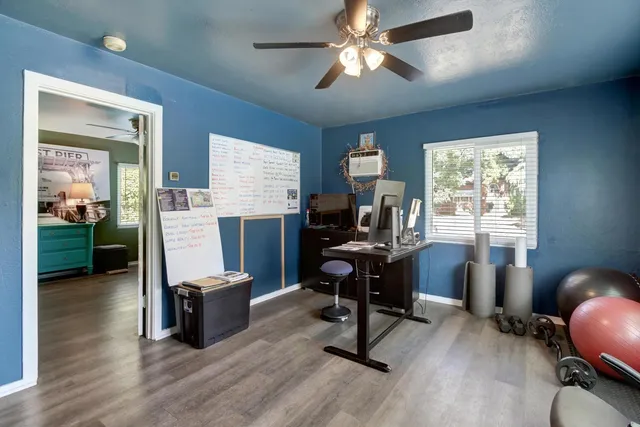 a view of a workspace with furniture and a window